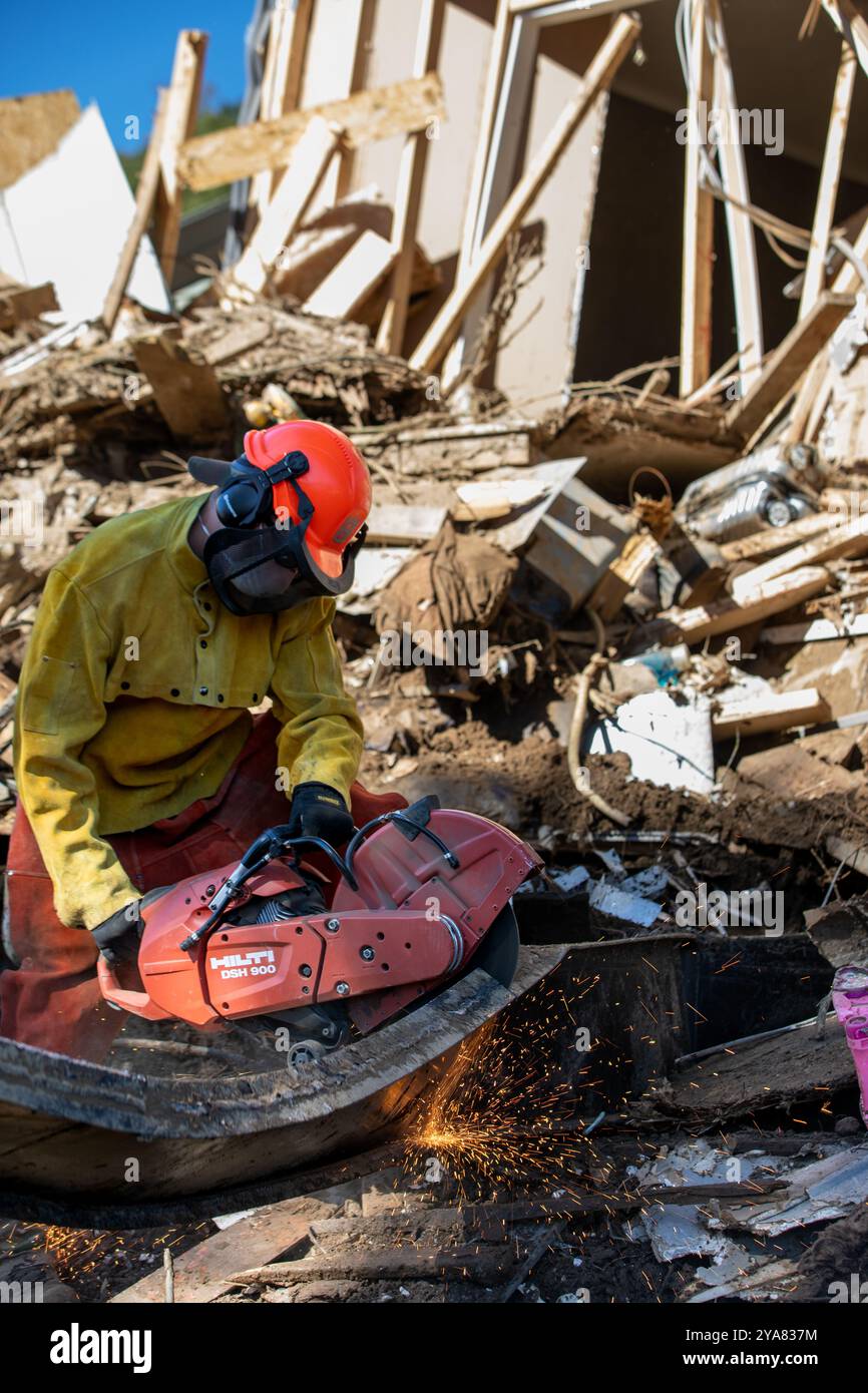 Comté de Washington, États-Unis. 11 octobre 2024. L'aviateur principal de la Garde nationale de l'air des États-Unis, Dylan Potts, avec le 134e civil Engineer Squadron, utilise un outil de coupe pour enlever les débris métalliques à la suite des inondations causées par l'ouragan Helene, le 11 octobre 2024 dans le comté de Washington, Tennessee. Crédit : Sgt. Everett Babbitt/US Air Force/Alamy Live News Banque D'Images