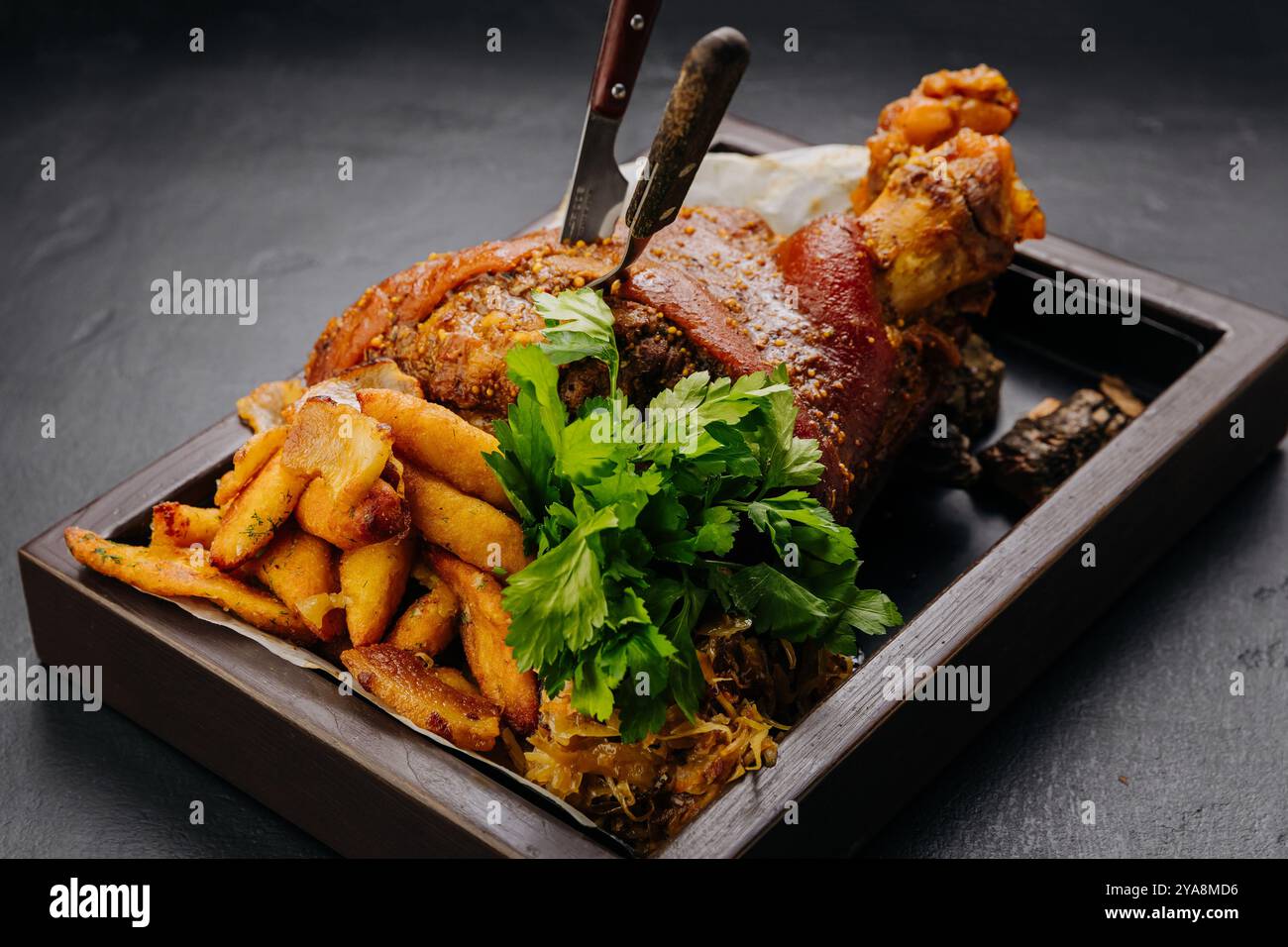 Jarret de porc rôti avec pommes de terre et herbes fraîches sur un plateau en bois, photographie de stock de nourriture Banque D'Images Jarret de porc rôti avec pommes de terre et herbes fraîches sur un plateau en bois, photographie de stock de nourriture Banque D'Images