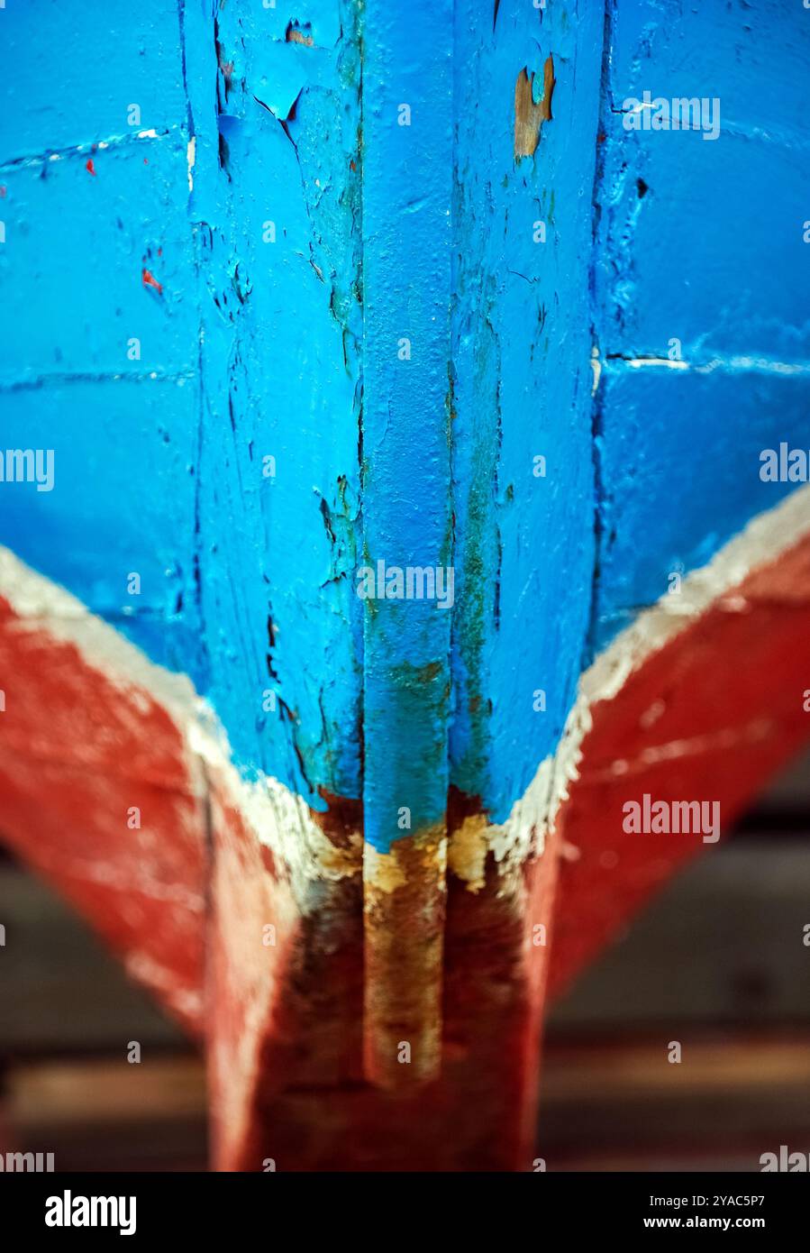 Photographie rapprochée d'un arc de quille peint en rouge, bleu et blanc d'un dory de pêche, dingy, bateau à rames. Banque D'Images