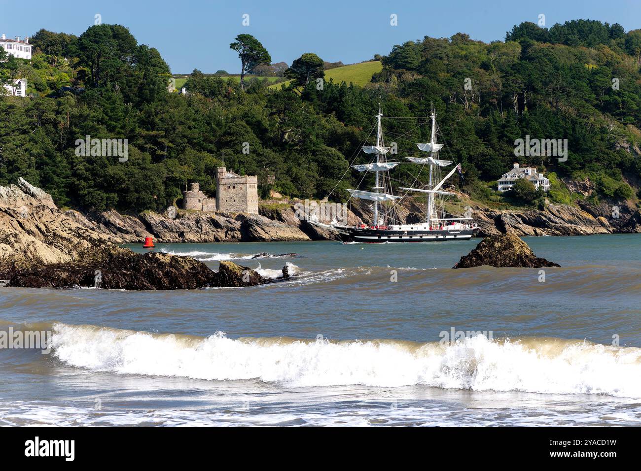 Vue sur l'estuaire de la rivière Dart depuis Sugar Cove avec le château Kingswear et le Brig d'entraînement TS Royalist de retour. Banque D'Images