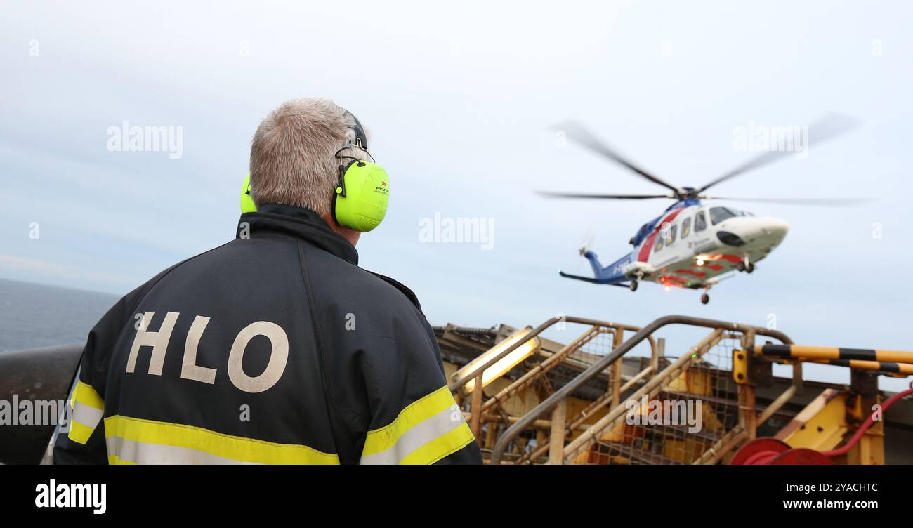 L'hélicoptère Landing Ofifcer ou HLO regarde un hélicoptère arriver sur une plate-forme pétrolière en mer du Nord Banque D'Images