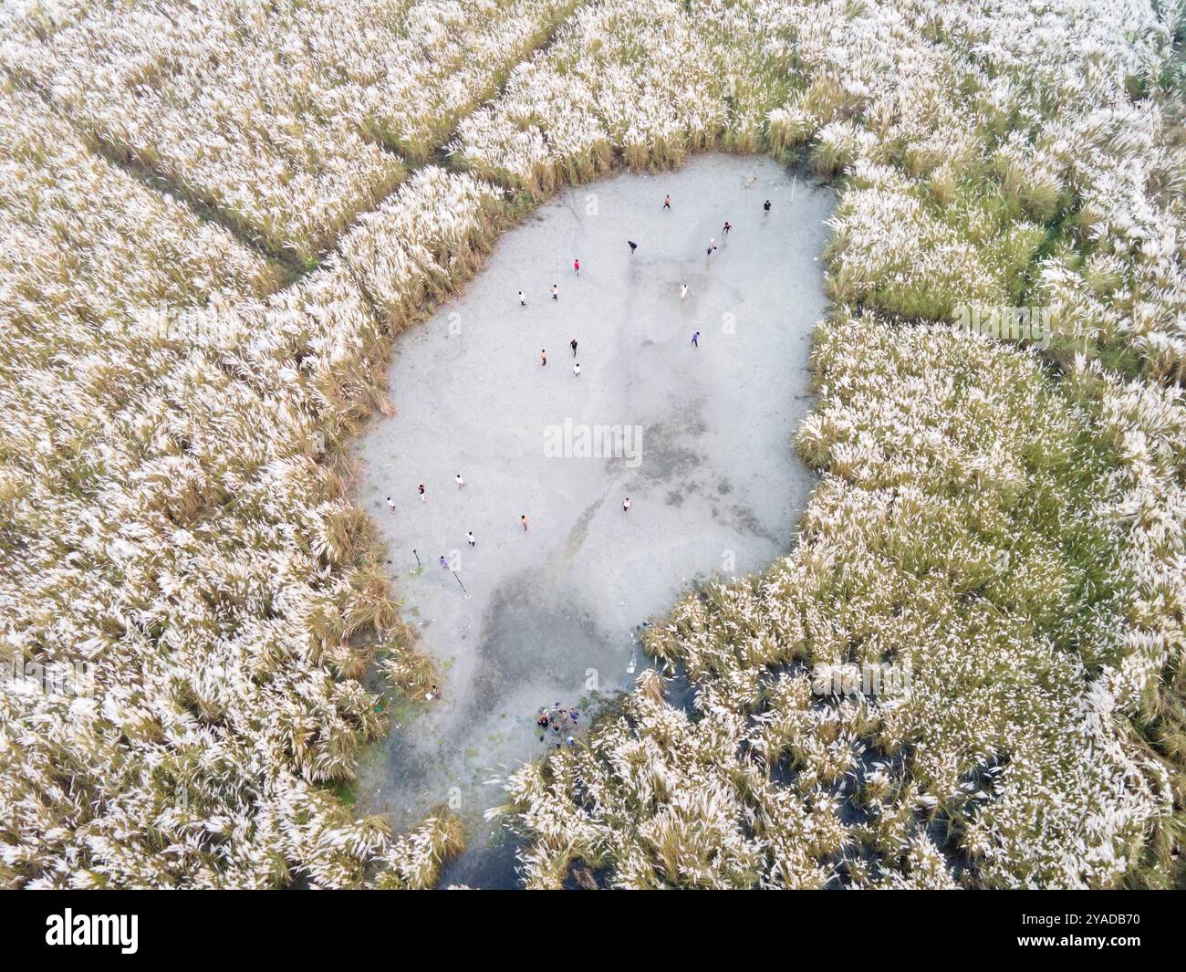 Dhaka, Bangladesh. 12 octobre 2024. Une vue aérienne montre des garçons jouant au football sur un terrain de sable permanent entouré de parterres de fleurs temporaires à Dhaka, au Bangladesh, le 12 octobre 2024. (Photo de Muhammad Amdad Hossain/NurPhoto) crédit : NurPhoto SRL/Alamy Live News Banque D'Images