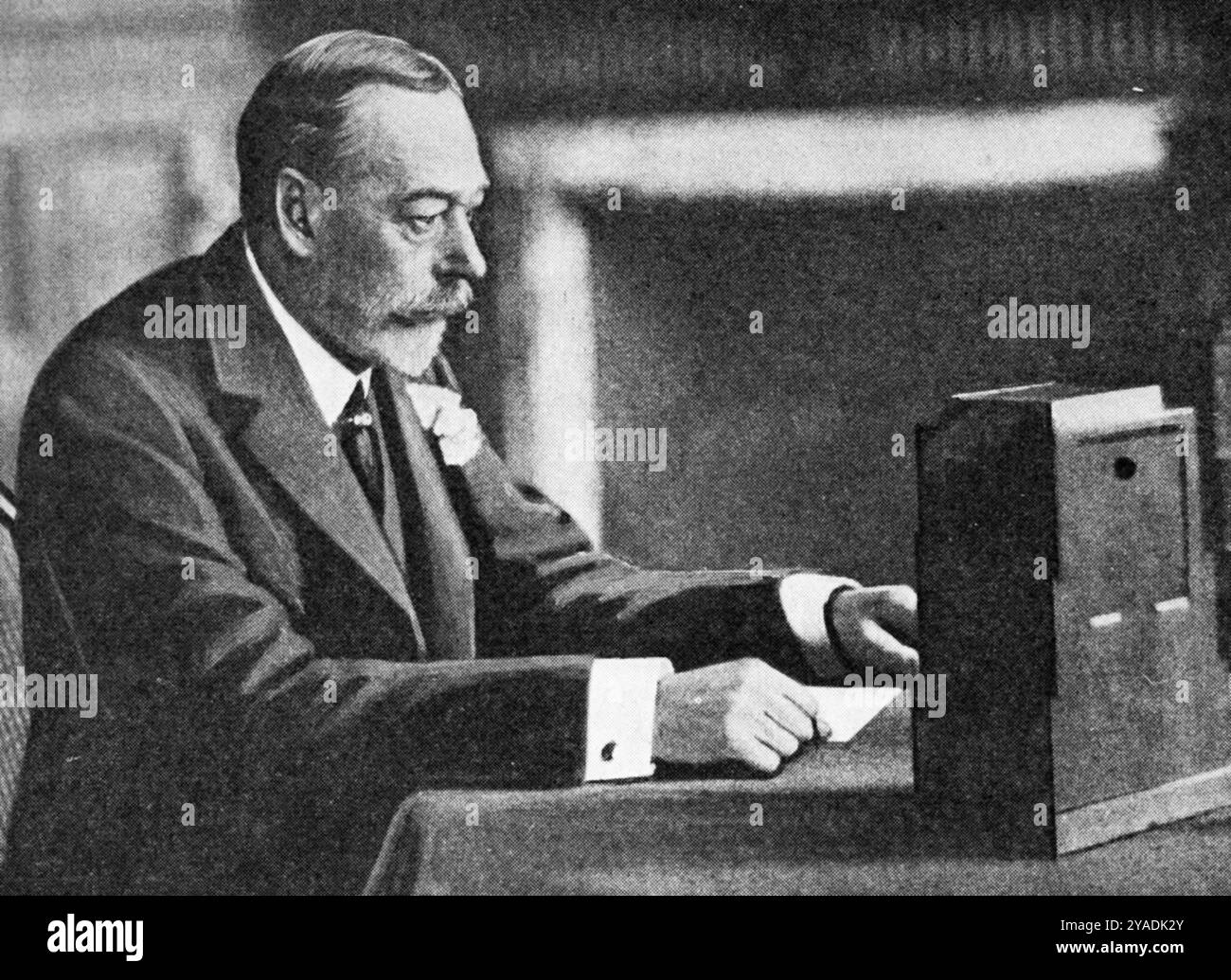 Le roi George V lisant le premier message royal de Noël, Sandringham House, le 25 décembre 1932. Le message de Noël de 1932 a été écrit par Rudyard Kipling (1865-1936). Il a été livré par le roi George V (1865-1936), d'un studio temporaire installé à Sandringham House. Banque D'Images