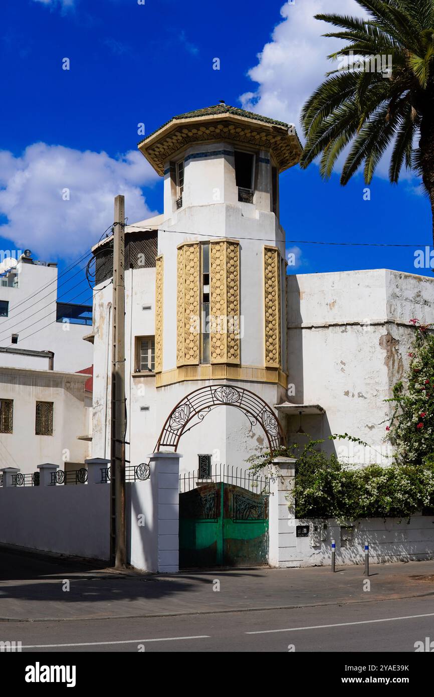 bâtiment historique avec une tour ornée aux motifs dorés complexes se dresse contre un ciel bleu vif. les tourelles , casablanca, Maroc Banque D'Images