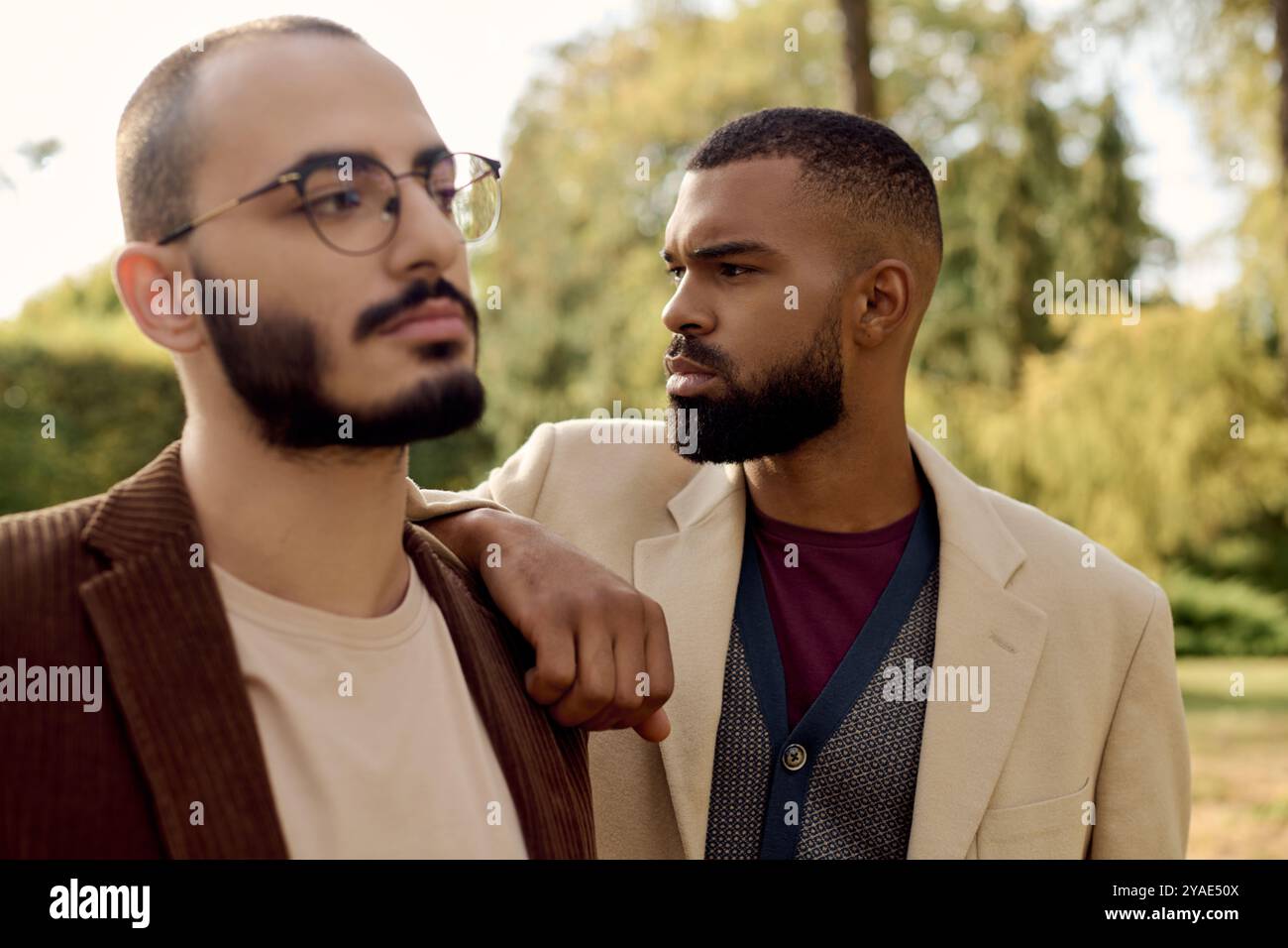 Deux hommes dapper en tenue d'automne à la mode profitent d'un moment tranquille dans un paysage d'automne coloré. Banque D'Images