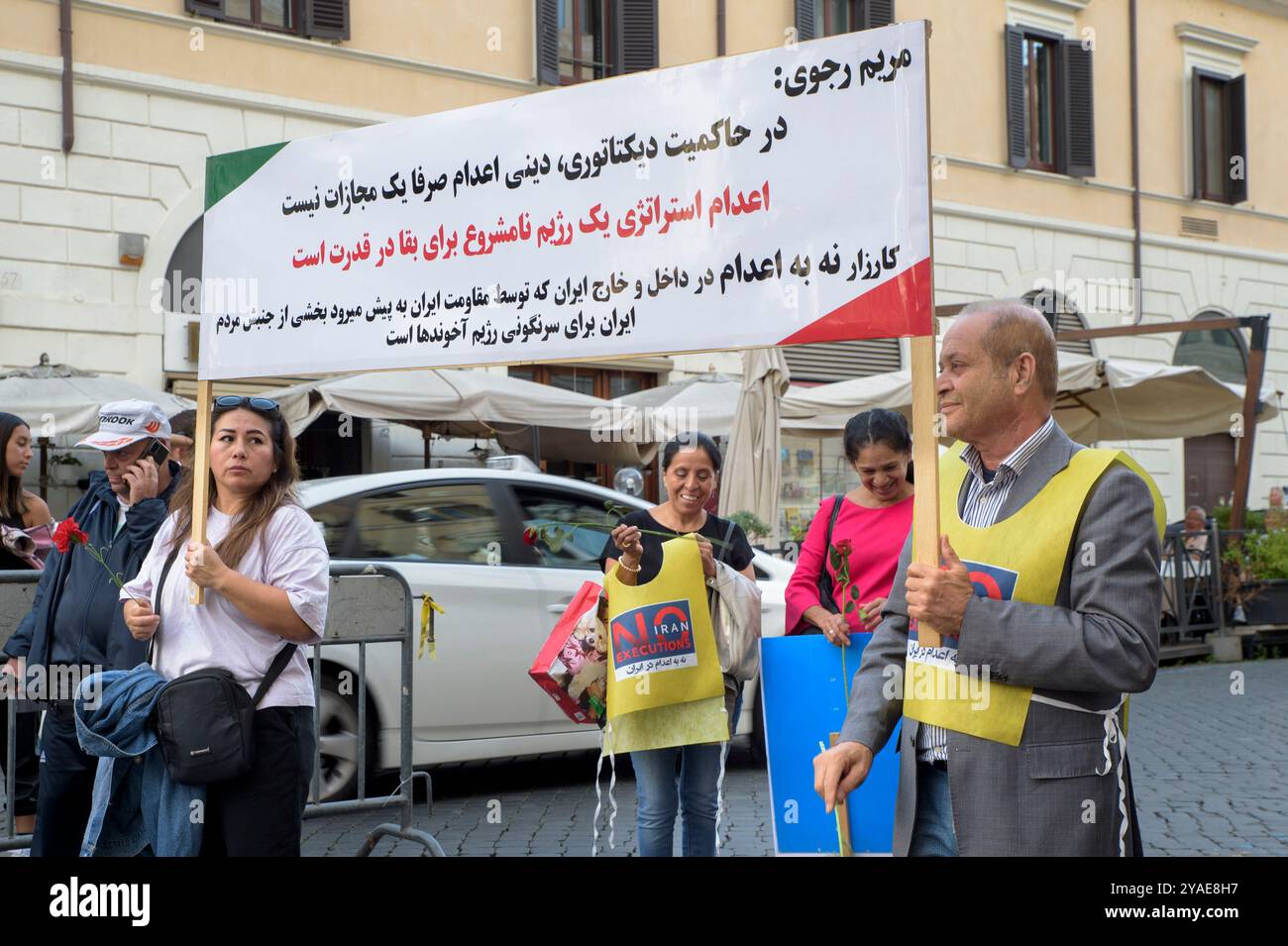 Rome, Italie. 12 octobre 2024. Deux manifestants brandissent une banderole avec quelques mots sur l'utilisation de la peine de mort par le "régime iranien" et attribuée dans le panneau à Maryam Rajavi lors de la manifestation contre les exécutions en Iran organisée par le Conseil national de la résistance iranienne à Rome. Certains représentants de la communauté iranienne de Rome et de ses environs ont manifesté pour sensibiliser le public aux exécutions capitales de prisonniers politiques en Iran. Selon le Conseil national de la résistance iranienne (CNRI), dans les jours qui entourent la Journée mondiale contre la peine de mort, Banque D'Images