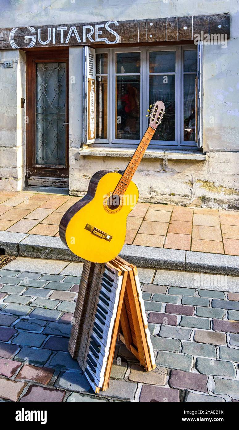 Afficher l'annonce avec guitare sur clavier à l'extérieur magasin de musique dans le centre-ville - Loches, Indre-et-Loire (37), France. Banque D'Images
