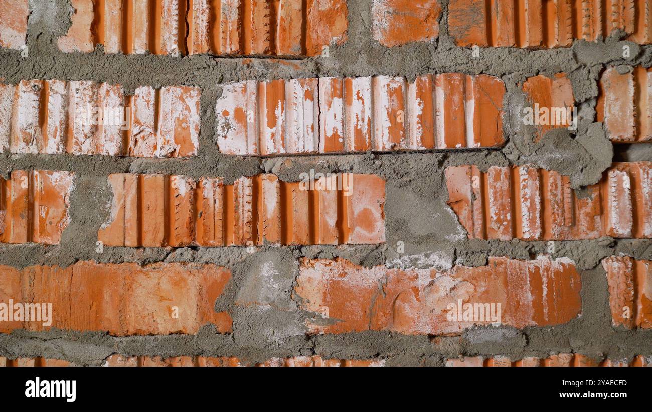 Fond de mur de briques rouges avec des joints de mortier épais, créant une surface texturée et rustique. Banque D'Images