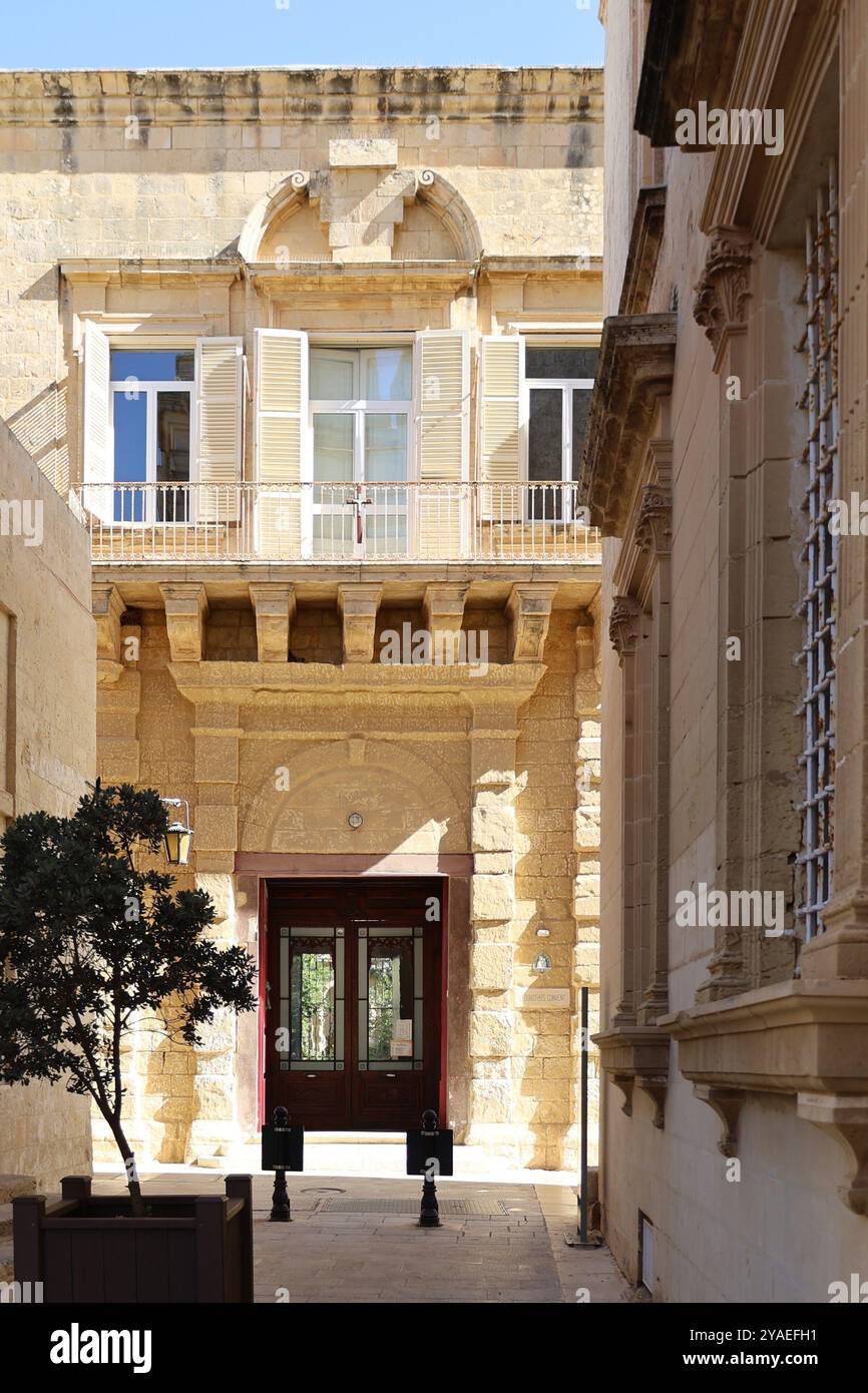 rote Tür. porte rouge. Eingang. entrée. Türklopfer. heurtoir de porte. Glastür. Kalkstein. calcaire. historisch. historique. ancien. été. Mdina. Malte. Banque D'Images