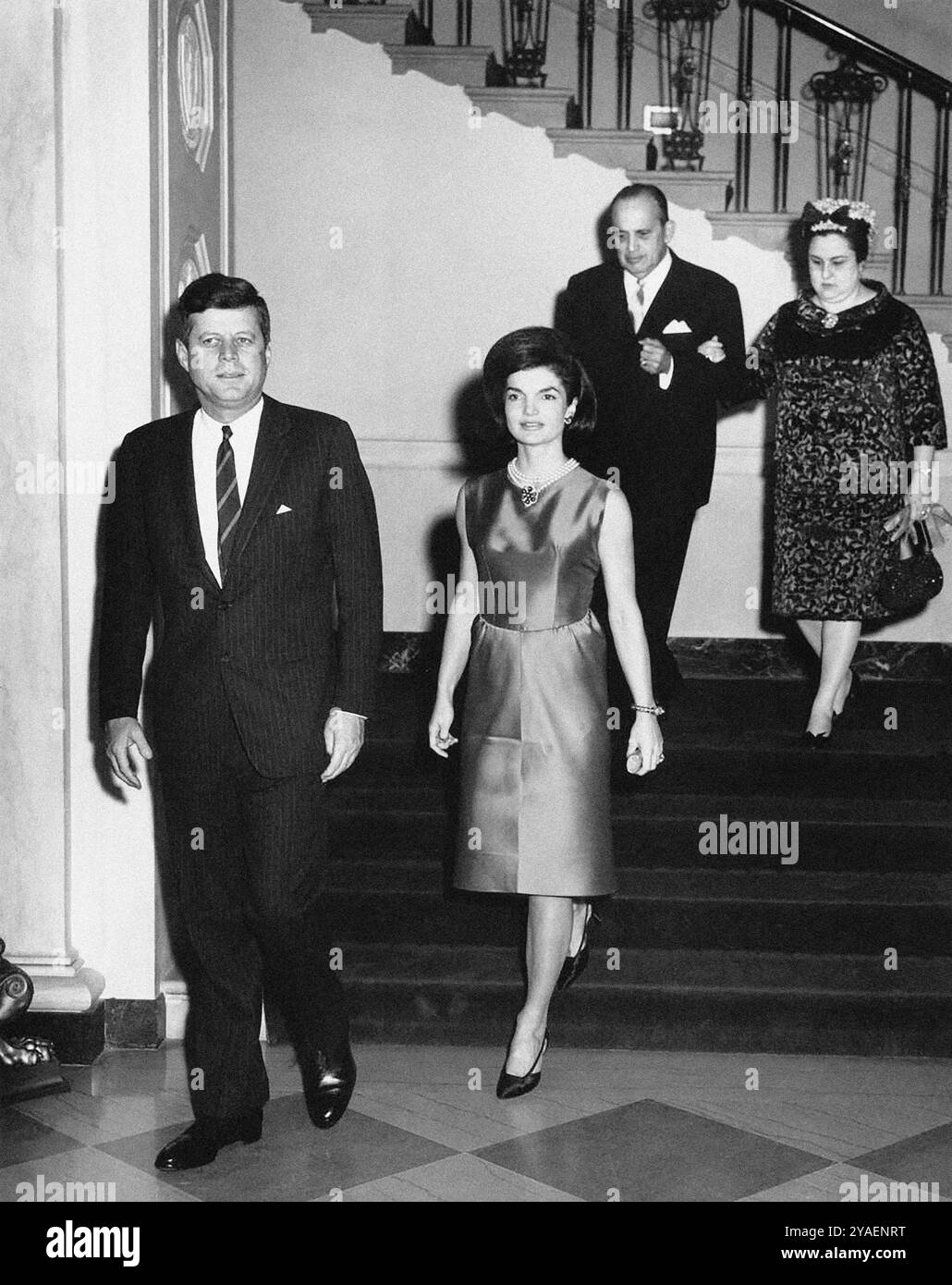 Le président américain John F. Kennedy et la première dame Jacqueline Kennedy arrivent dans le hall d'entrée pour la réception diplomatique, l'ambassadeur du Nicaragua et doyen du corps diplomatique, le Dr Guillermo Sevilla-Sacasa, et Lillian Somoza de Sevilla-Sacasa en arrière-plan, Maison Blanche, Washington, D.C. Abbie Rowe, photographies de la Maison Blanche, 21 février 1963 Banque D'Images