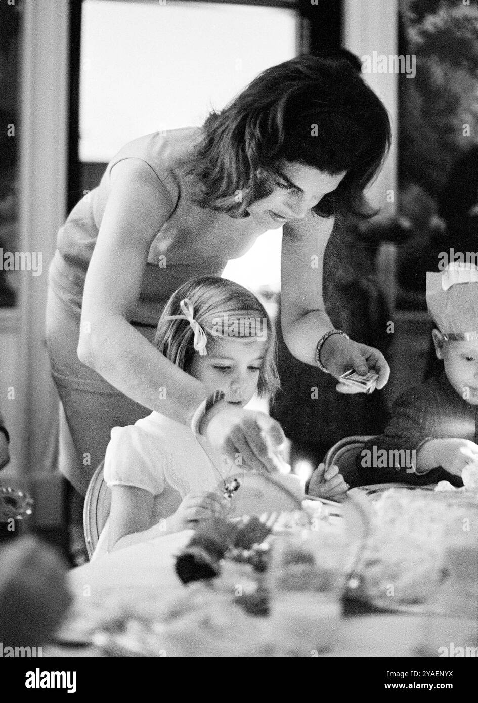 La première dame des États-Unis Jacqueline Kennedy allumant une bougie d’anniversaire pour sa fille, Caroline Kennedy, lors d’une fête conjointe pour Caroline et John F. Kennedy, Jr., salle à manger du président, Maison Blanche, Washington, DC, USA, Cecil Stoughton, White House Photographs, 14 novembre, 1962 Banque D'Images