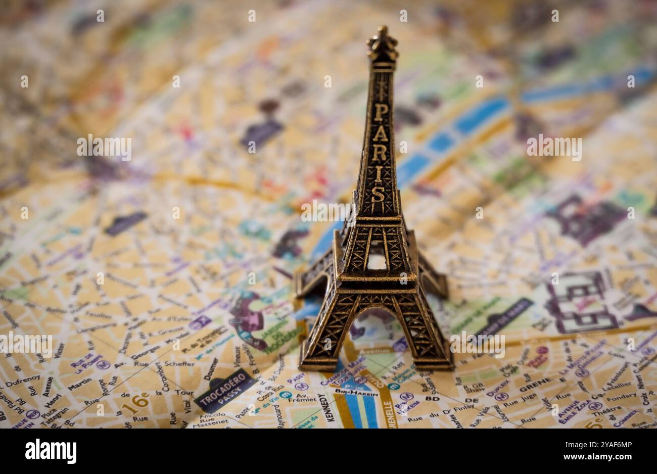 Une réplique miniature en métal de la Tour Eiffel plane sur un plan de rue de Paris en papier pour illustration et utilisation conceptuelle Banque D'Images