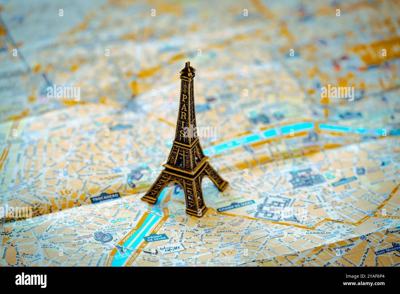 Une réplique miniature en métal de la Tour Eiffel se dresse sur un plan de rue de Paris en papier pour illustration et divertissement Banque D'Images