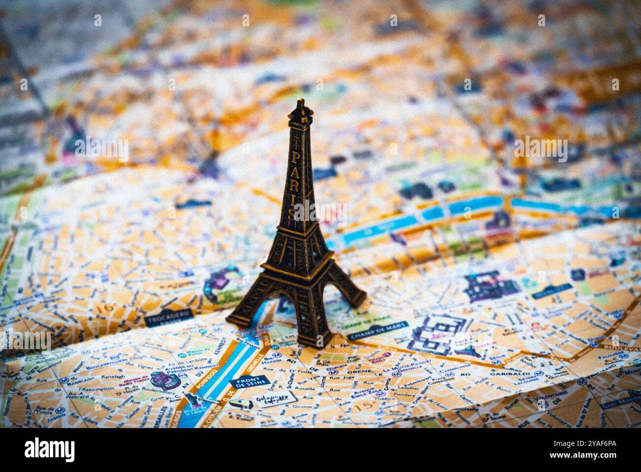 Une réplique miniature en métal de la Tour Eiffel plane sur un plan de rue de Paris en papier pour illustration et utilisation conceptuelle Banque D'Images