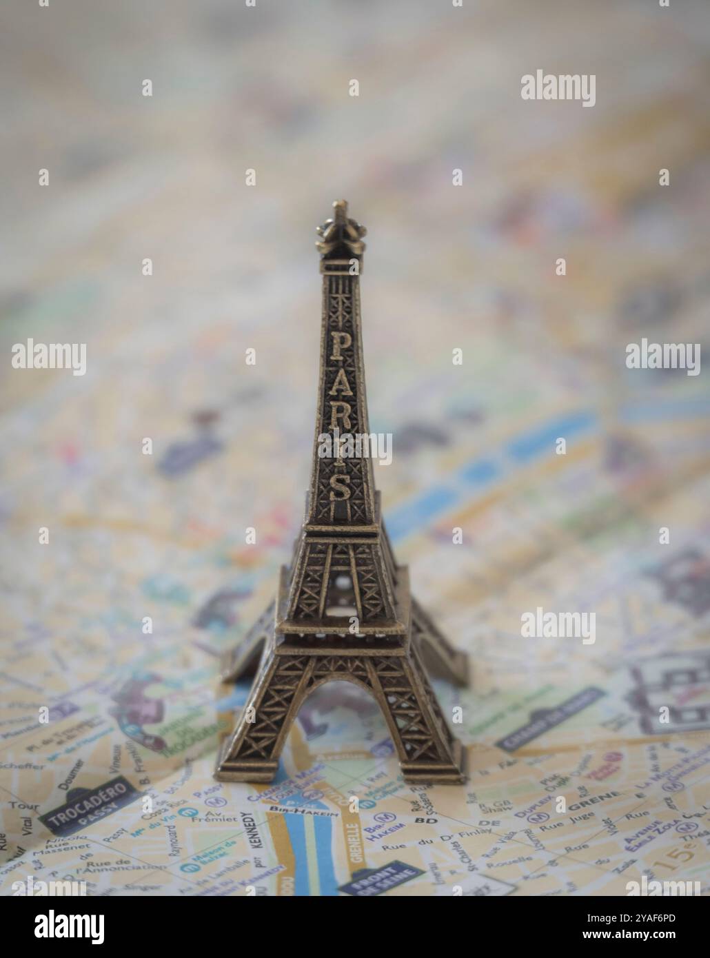 Une réplique miniature en métal de la Tour Eiffel se dresse sur un plan de rue de Paris en papier pour illustration et divertissement Banque D'Images