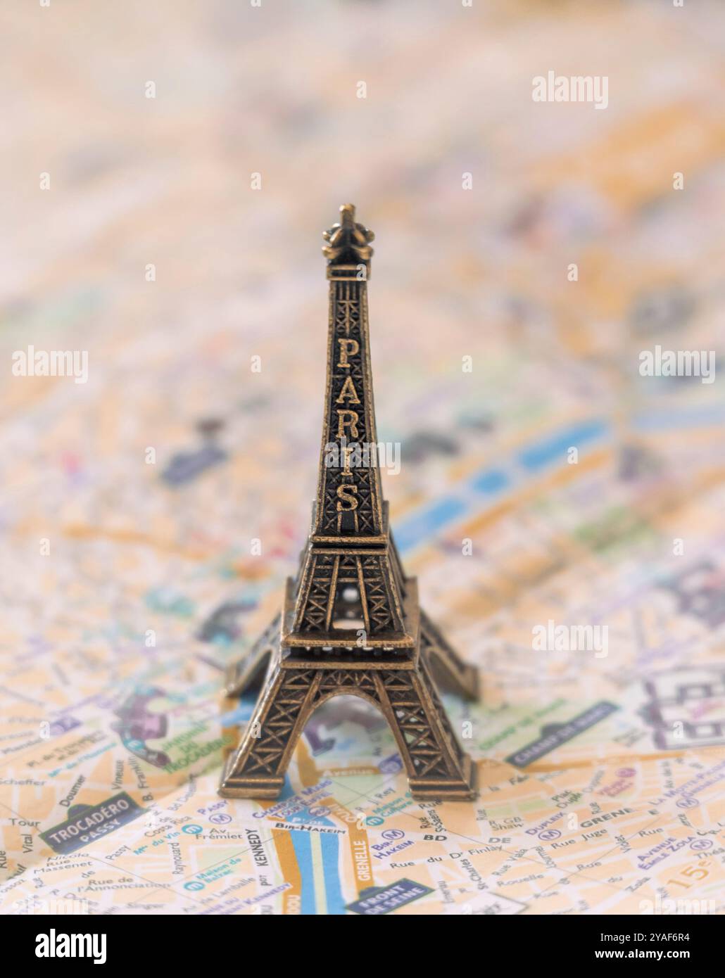 Une réplique miniature en métal de la Tour Eiffel se dresse sur un plan de rue de Paris en papier pour illustration et divertissement Banque D'Images