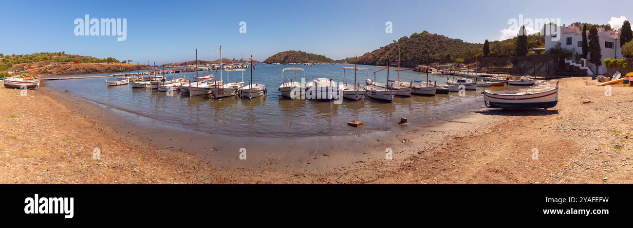 Vue panoramique de petits bateaux de pêche amarrés dans les eaux calmes de la baie de Port Lligat, située près de Cadaques, Espagne Banque D'Images