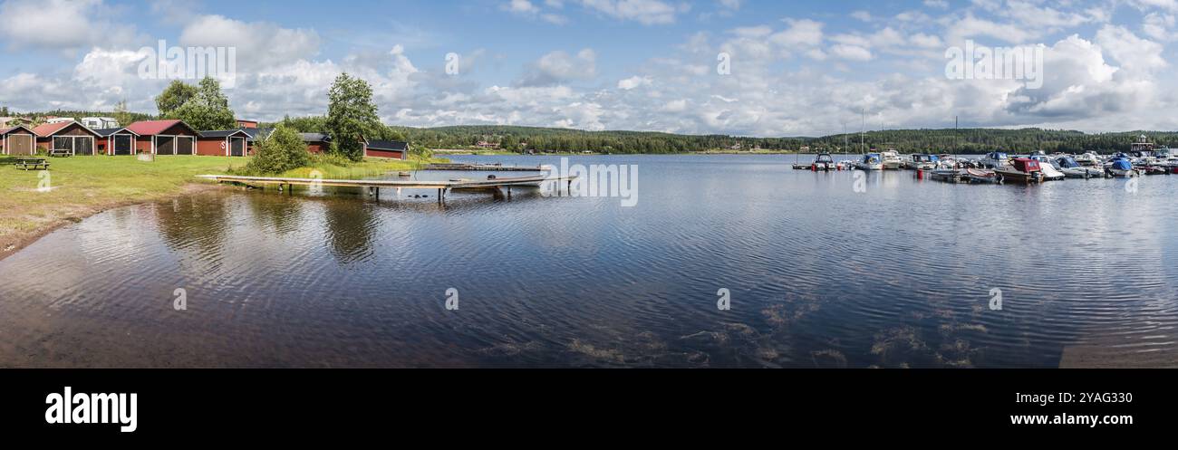 Segersta, Halsingland, Suède, 08 04 2019 très grande vue panoramique sur un camping avec une eau calme réfléchissante et de petites maisons de vacances en bois rouge, UE Banque D'Images