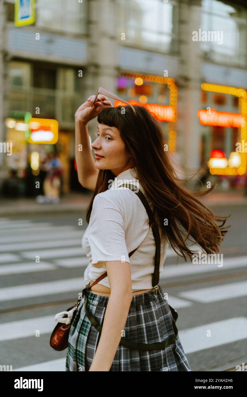 Jeune femme marchant dans la rue de la ville pendant l'été. Banque D'Images