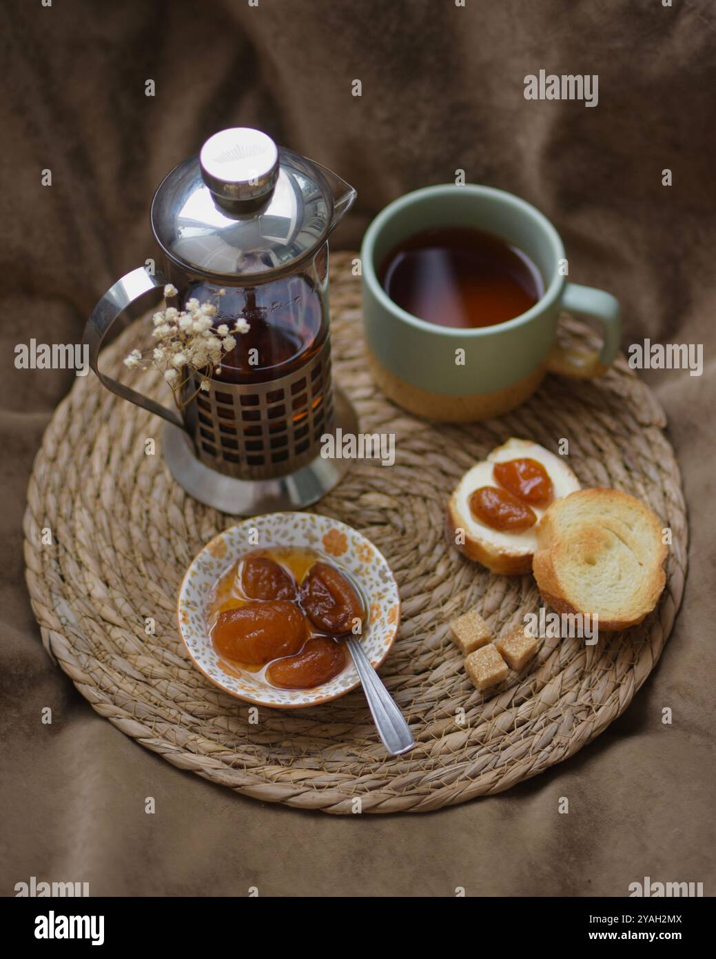Théière, tasse de thé et baguette avec confiture d'abricot Banque D'Images