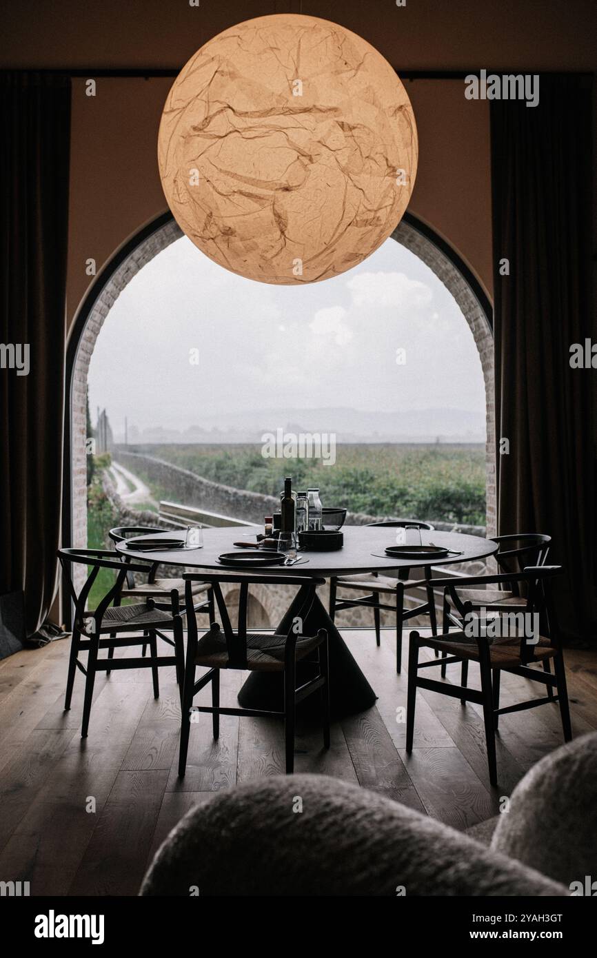 Salle à manger moderne avec table ronde et vue panoramique sur le vignoble Banque D'Images