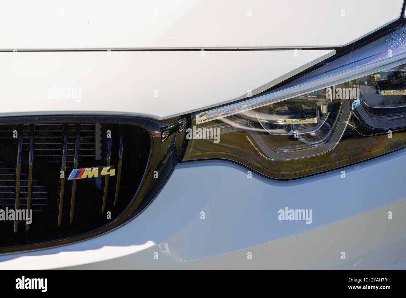 Gros plan du phare blanc d'une bmw m4, mettant en valeur le design sportif et le logo emblématique Banque D'Images