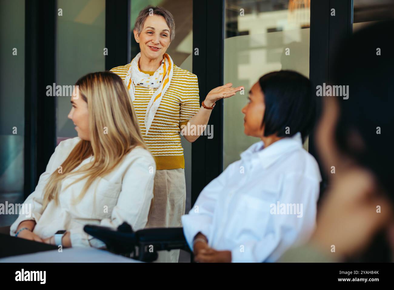 Un enseignant dynamique interagissant avec une petite classe, créant une atmosphère d'apprentissage positive et inclusive avec des élèves attentifs et diversifiés. Banque D'Images