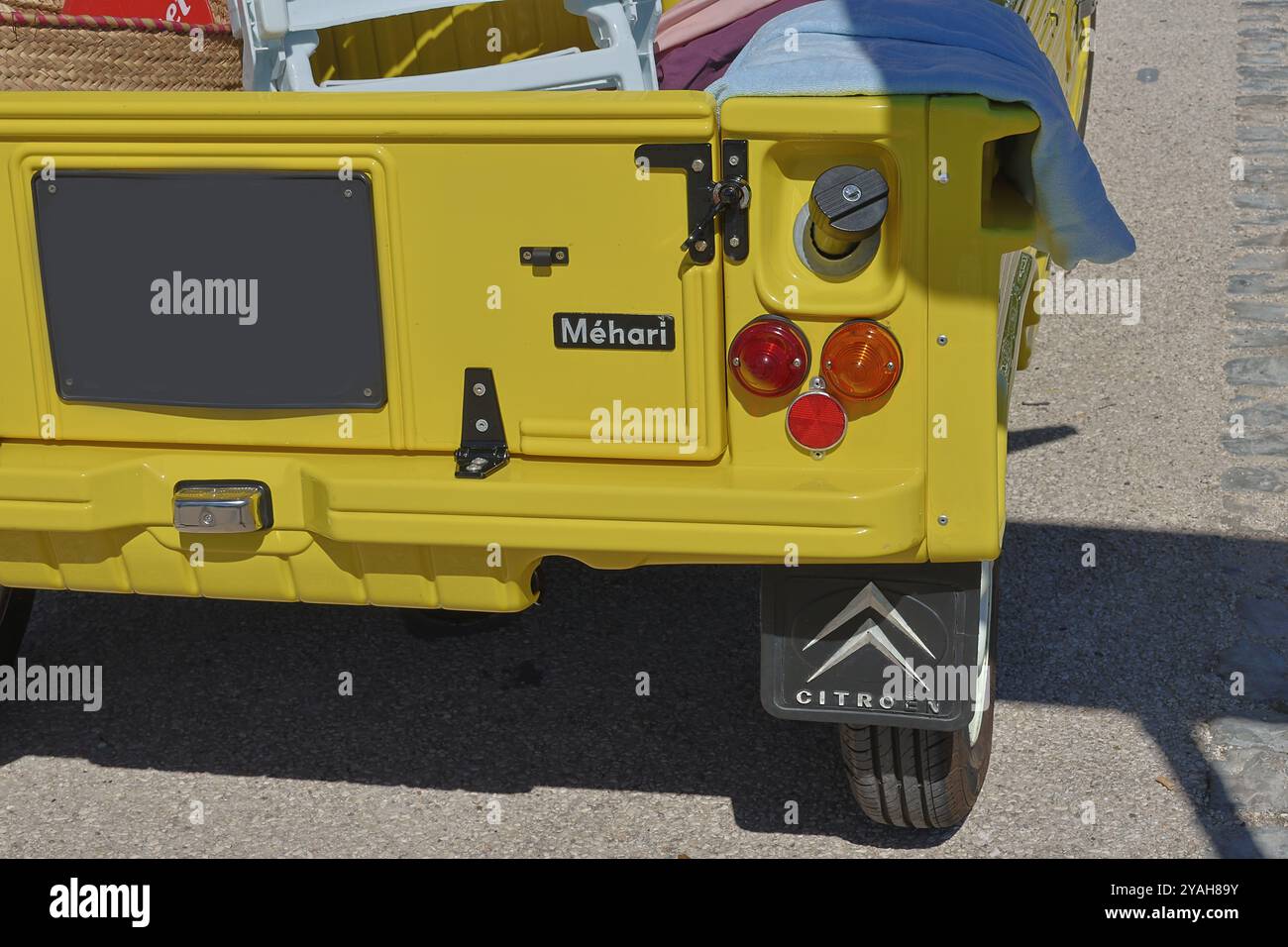 Gros plan à l'arrière de citroën mehari jaune avec pneu de secours, corps en plastique et chaises pliantes dans le lit, garé à l'extérieur par jour ensoleillé Banque D'Images