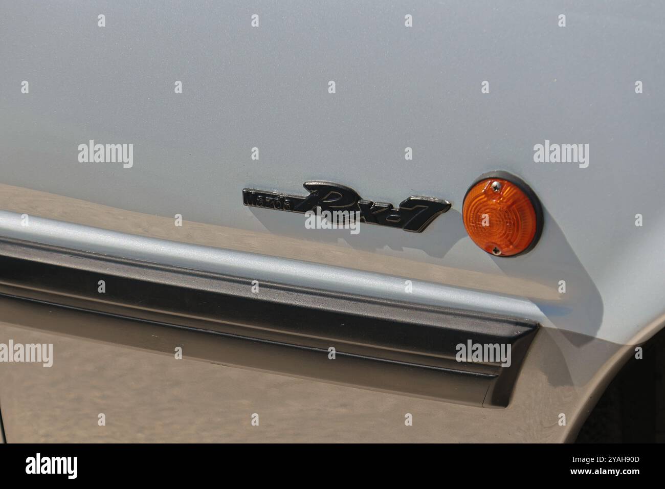 Le logo emblématique mazda rx 7 brille sur le côté d'une voiture argentée Banque D'Images