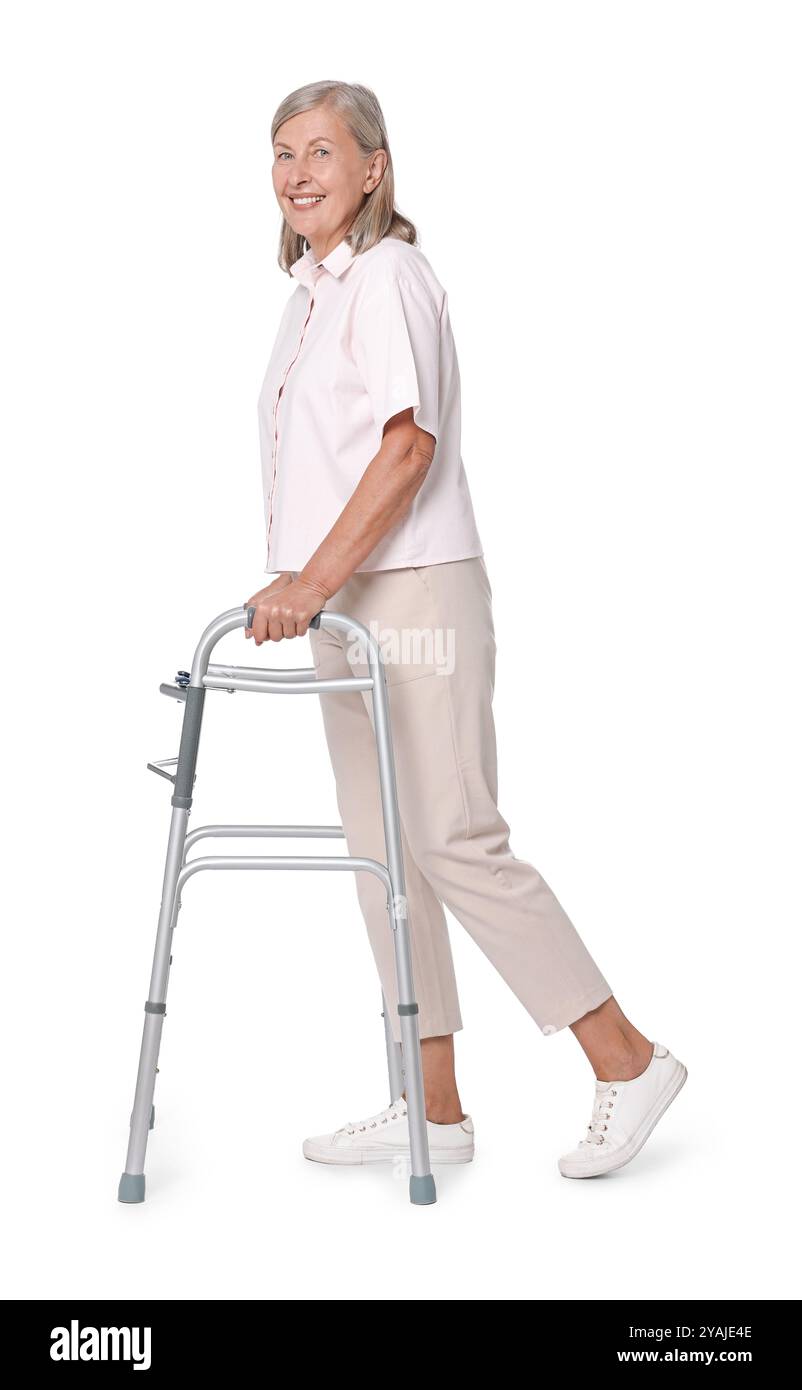 Femme senior utilisant le cadre de marche sur fond blanc Banque D'Images