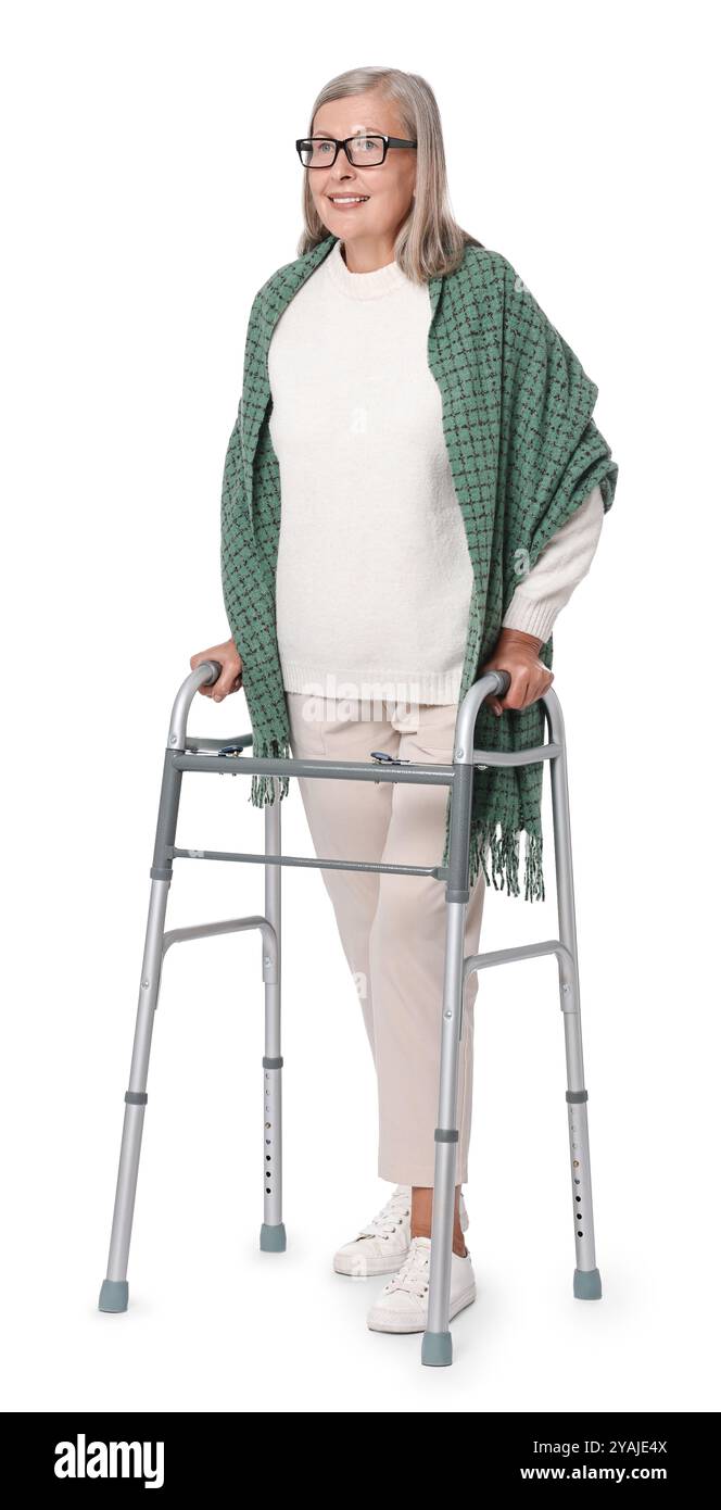 Femme senior utilisant le cadre de marche sur fond blanc Banque D'Images