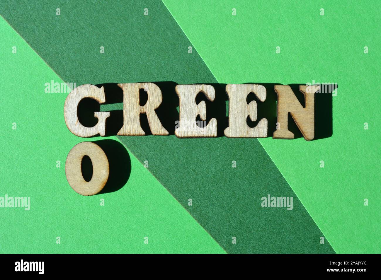 Go Green, mots en lettres de l'alphabet en bois sous forme de mots croisés isolés sur fond vert Banque D'Images