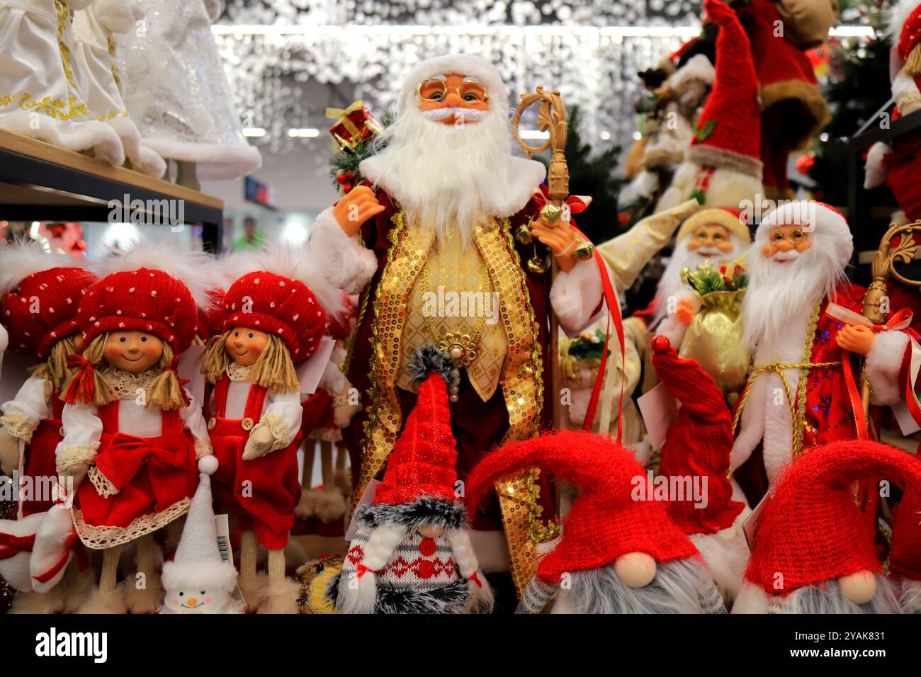 Drôle rouge souriant Père Noël, beaux jouets du nouvel an et de Noël, décorations et cadeaux. Shopping festif de Noël en hiver. Magasin de jouets 2025 Banque D'Images