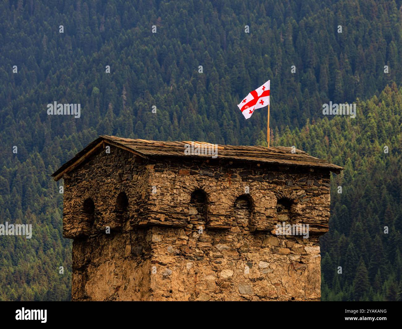 le drapeau de la géorgie flotte au sommet de l'une des tours défensives médiévales de mestia georgia Banque D'Images