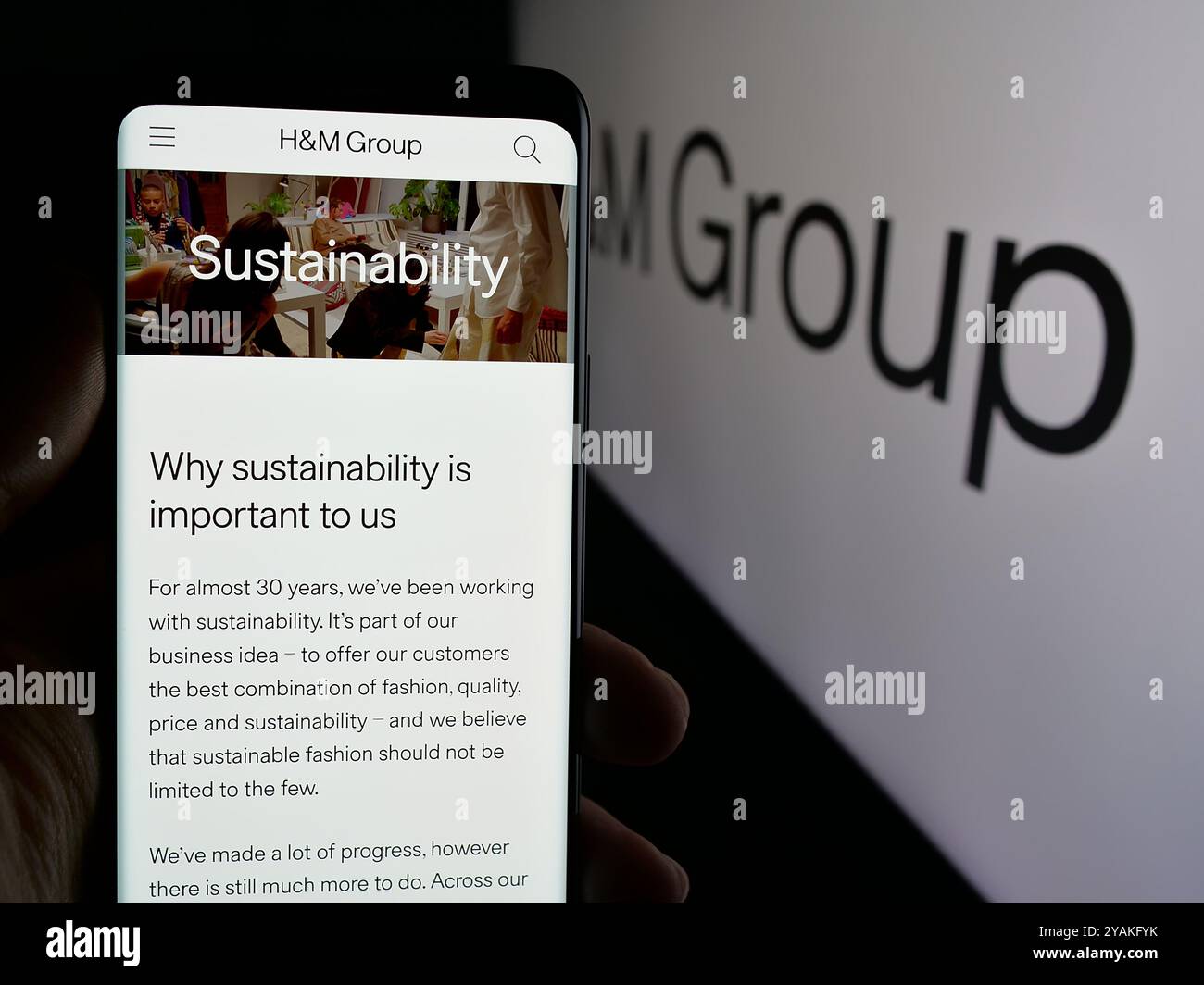 Personne tenant le téléphone portable avec la page Web de la société de mode suédoise H M Hennes Mauritz AB sur l'écran avec logo. Concentrez-vous sur le centre de l'écran du téléphone. Banque D'Images