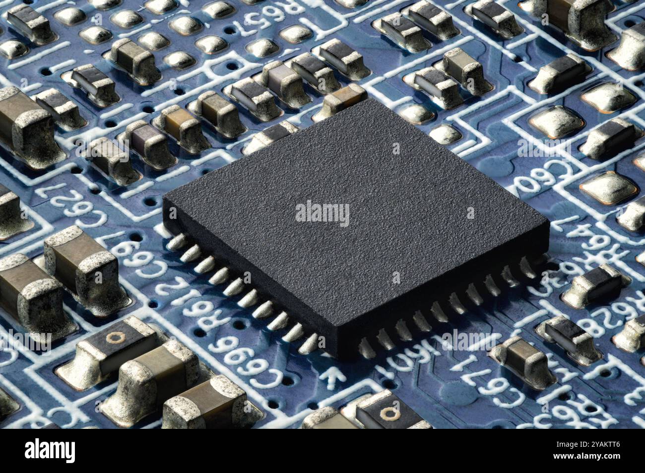 Petit semi-conducteur sur une plaquette de circuit imprimé. Gros plan extrême d'une puce intégrée dans un appareil électronique moderne Banque D'Images
