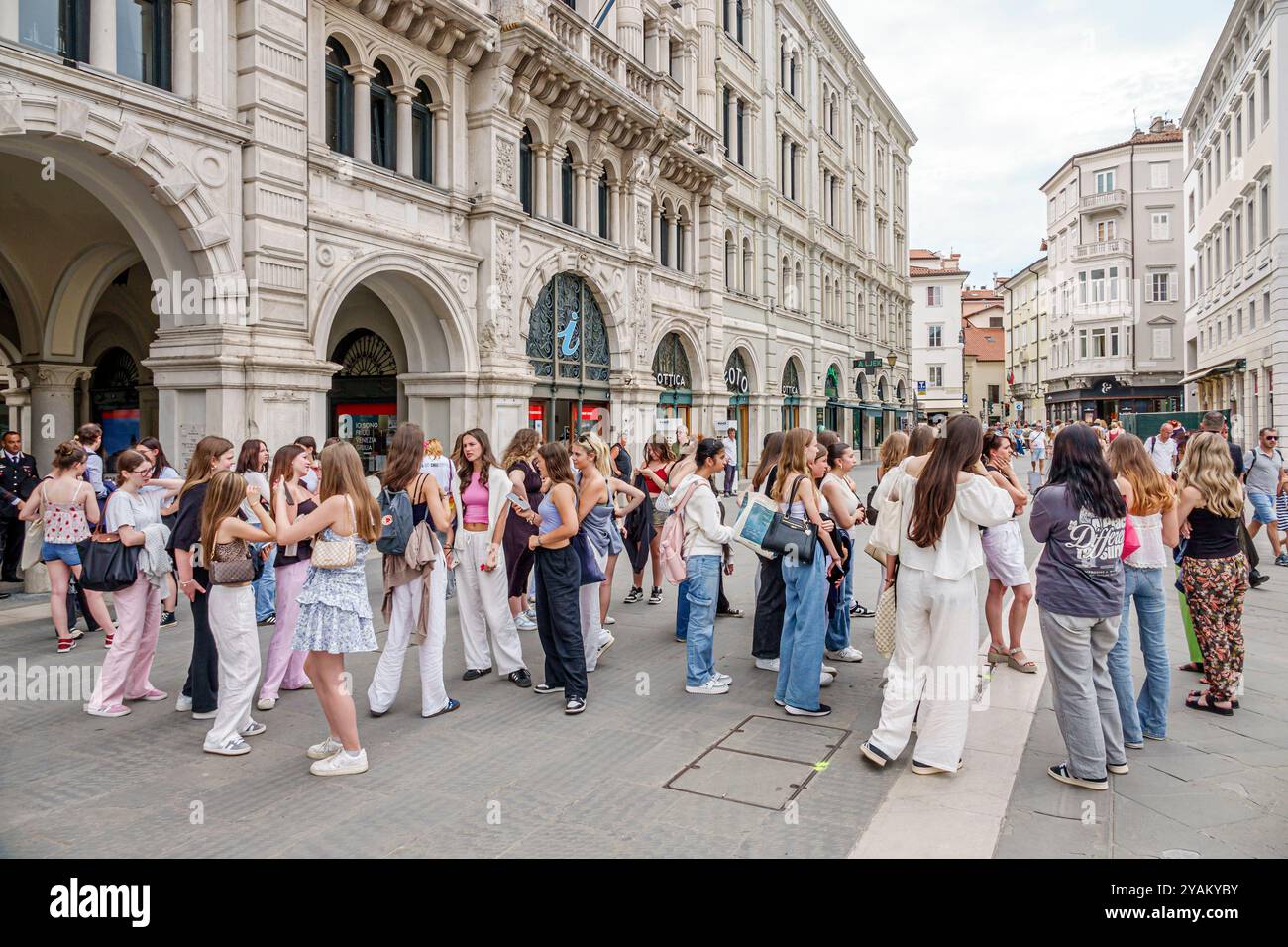 Trieste Italie, Piazza della Borsa, groupe de jeunes filles, école de classe voyage sur le terrain, Palazzo della Borsa Vecchia, Old Stock Exchange Palace, arc de style néoclassique Banque D'Images