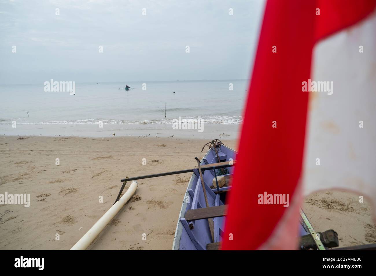 Photo d'un bateau naviguant de la plage vu de derrière le drapeau indonésien Banque D'Images