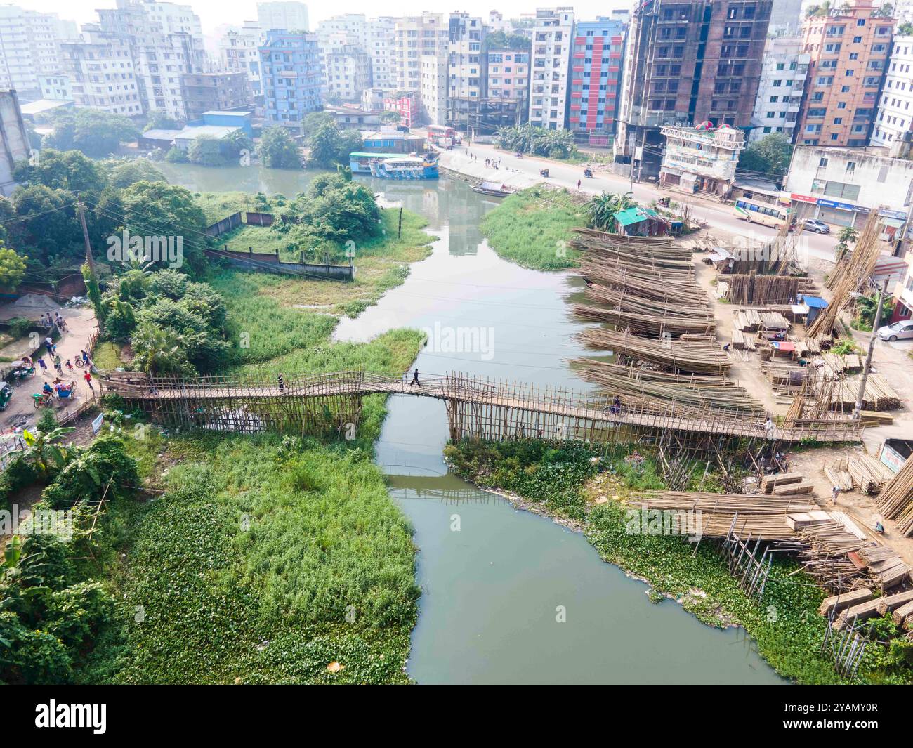 Dhaka, Dhaka, Bangladesh. 13 octobre 2024. 13 octobre 2024, Dhaka, Bangladesh : vue aérienne du Bangladesh des centaines de personnes utilisent le pont en bambou de fortune sur le canal à Banasree dans la capitale, Dhaka, Bangladesh. La structure de fortune est le seul moyen de communication routière pour les habitants de la région. (Crédit image : © Muhammad Amdad Hossain/ZUMA Press Wire) USAGE ÉDITORIAL SEULEMENT! Non destiné à UN USAGE commercial ! Banque D'Images