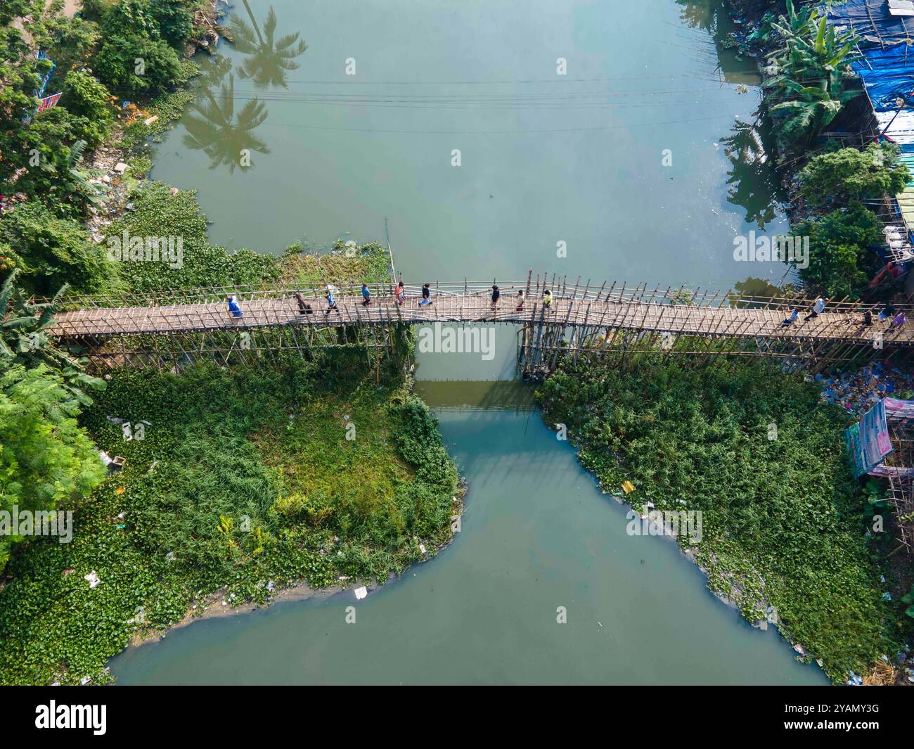 Dhaka, Dhaka, Bangladesh. 13 octobre 2024. 13 octobre 2024, Dhaka, Bangladesh : vue aérienne du Bangladesh des centaines de personnes utilisent le pont en bambou de fortune sur le canal à Banasree dans la capitale, Dhaka, Bangladesh. La structure de fortune est le seul moyen de communication routière pour les habitants de la région. (Crédit image : © Muhammad Amdad Hossain/ZUMA Press Wire) USAGE ÉDITORIAL SEULEMENT! Non destiné à UN USAGE commercial ! Banque D'Images