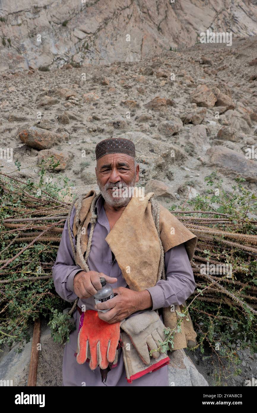 Homme portant une botte de bois dans la vallée de Nangma, Kanday, Baltistan, Pakistan Banque D'Images