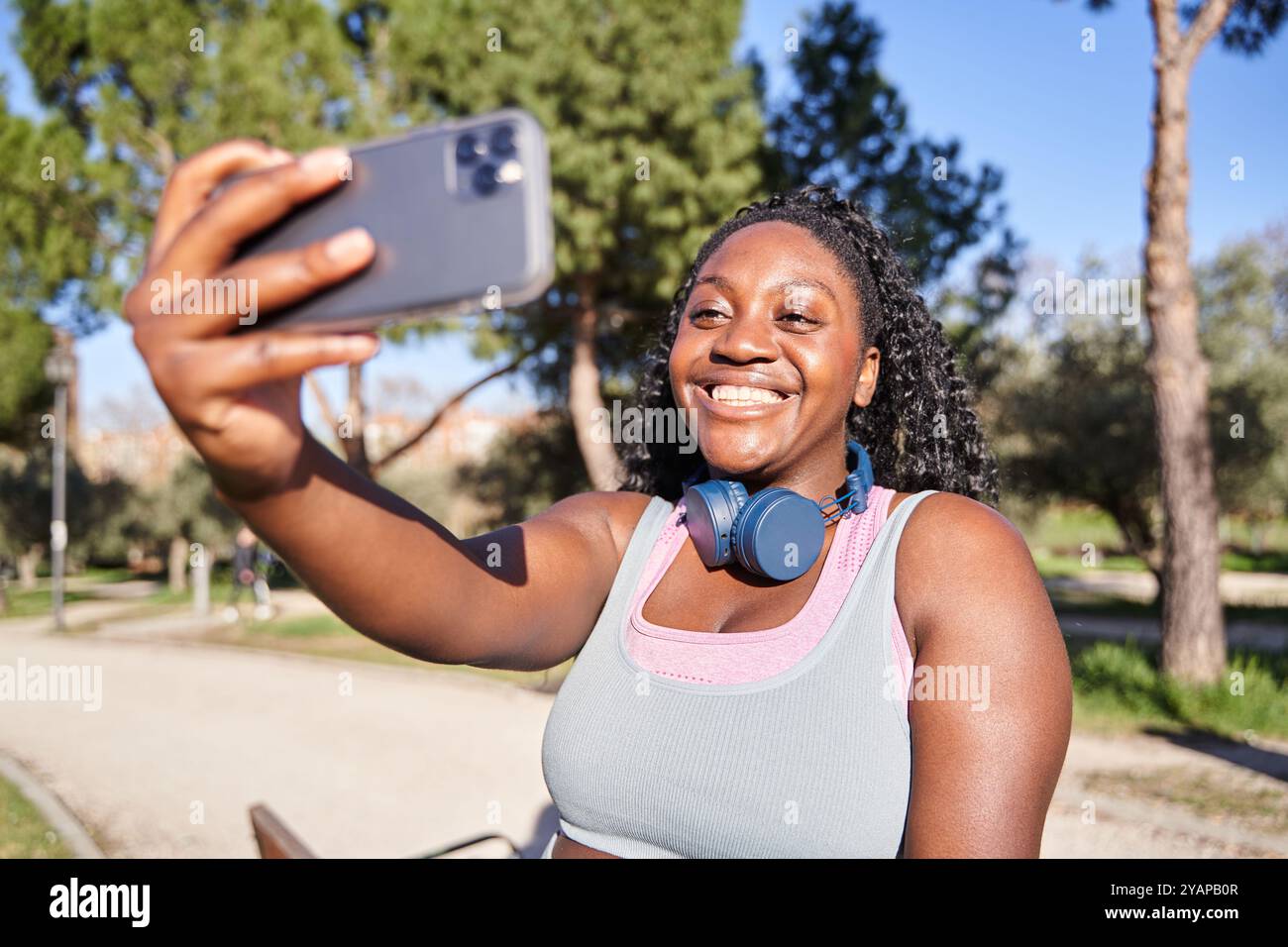 femme afro-américaine prenant un selfie avant l'entraînement. femme courbée portant des vêtements de sport. Banque D'Images