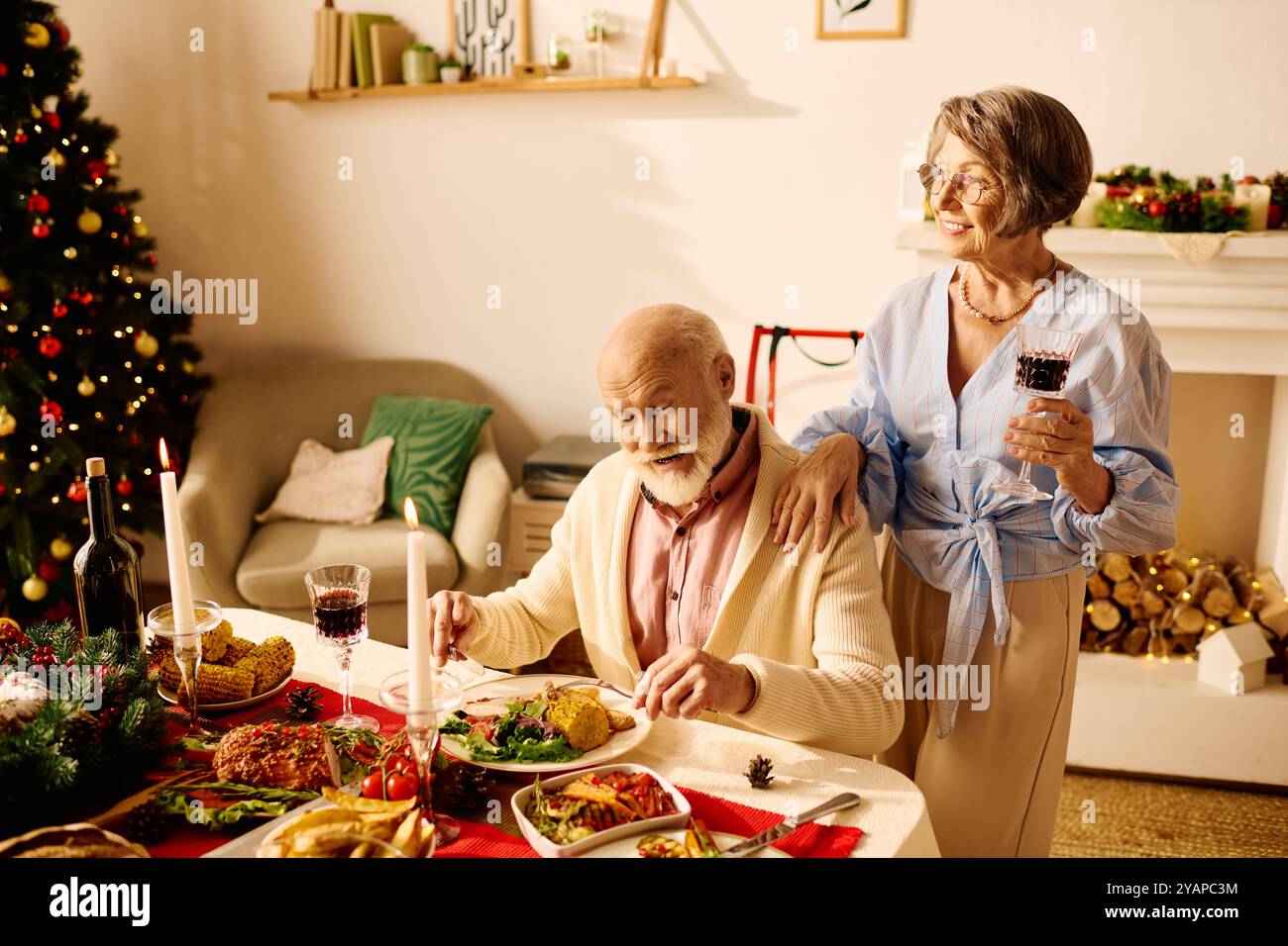 Le couple partage un repas festif, rempli d'amour et d'esprit de vacances à la maison. Banque D'Images