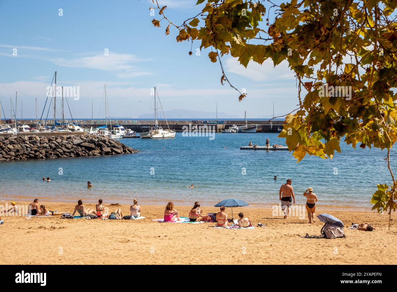 Les vacanciers et les gens qui prennent le soleil en vacances sur la plage faite par l'homme à Machico la deuxième plus grande ville / station balnéaire sur l'île portugaise de Madère Banque D'Images