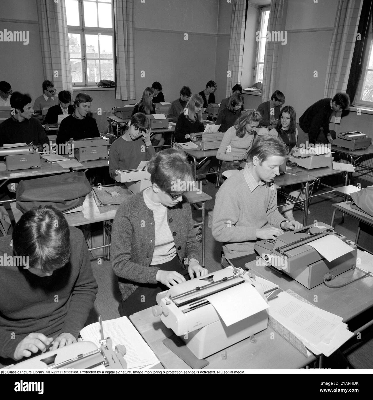 Apprendre à taper dans les années 1960 Une salle de classe d'étudiants assis à des machines à écrire. Une classe et une éducation à la frappe, en utilisant les doigts et les touches droites. 1968. Conard ref 5573 Banque D'Images