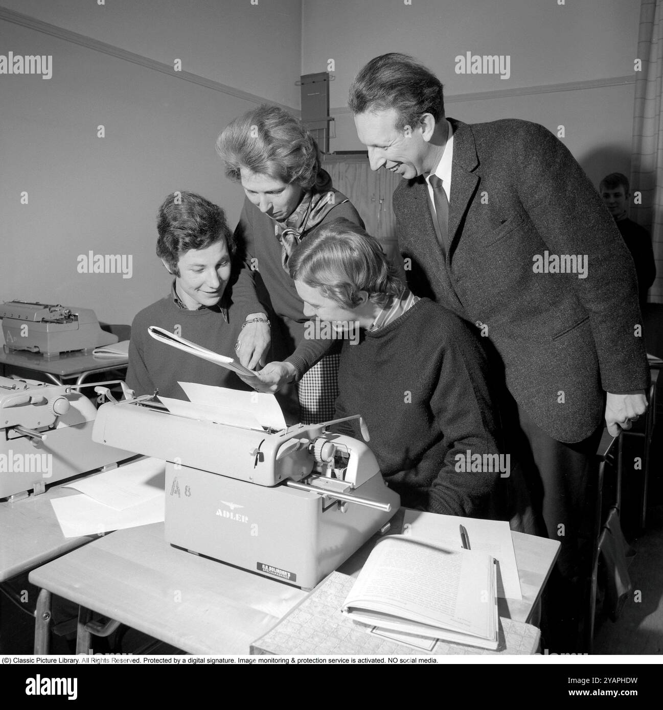 Apprendre à taper dans les années 1960 Une salle de classe d'étudiants assis à des machines à écrire. Une classe et une éducation à la frappe, en utilisant les doigts et les touches droites. Deux professeurs dans la photo. 1968. Conard ref 5573 Banque D'Images