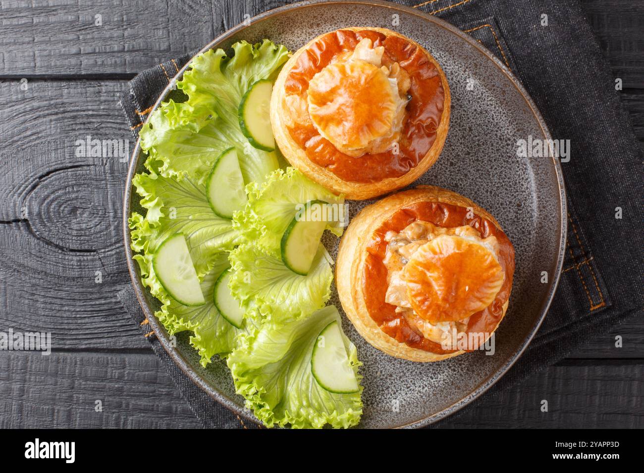 Délicieux Bouchee classique vol-au-vent farci de ragoût de bœuf gros plan dans une assiette sur une table en bois. Vue horizontale de dessus Banque D'Images