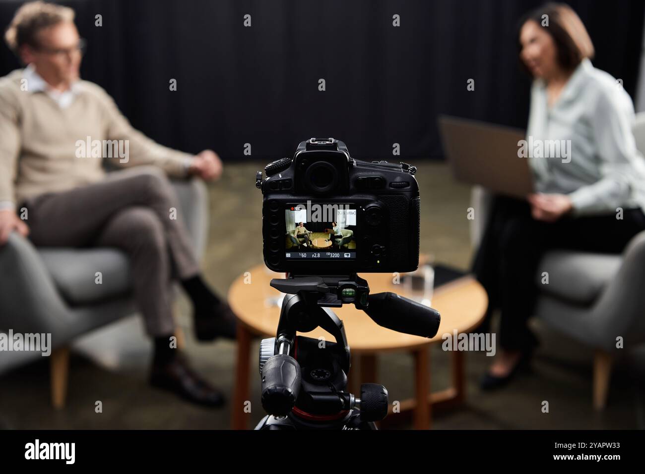 Un journaliste entretient avec un spécialiste une discussion réfléchie, capturant des idées dans un cadre professionnel. Banque D'Images