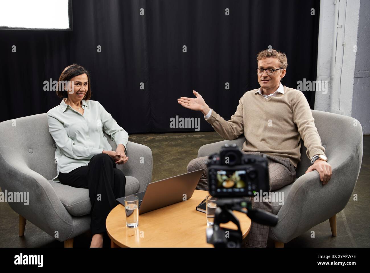 Une journaliste d’âge moyen engage un spécialiste dans une discussion réfléchie sur des sujets d’actualité. Banque D'Images