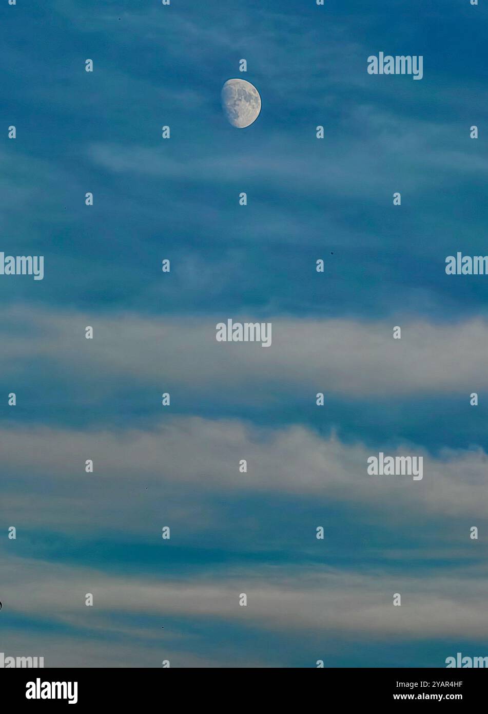 Haut dans le ciel : phase de lune comme satellite de la Terre avec nuages comme lignes directrices, concept Top of the World Banque D'Images